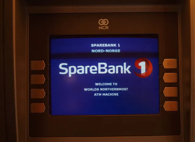 A cash machine screen in a dark frame showing the SpareBank 1 logo and the message Welcome to world's northernmost ATM machine
